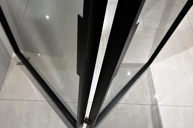 LIBRO-SLIM, модель Space, прозрачное стекло GT02 Trasparente Grafite. Алюминиевый каркас полотна и ручка в отделке AL08 Black. Фрагмент двери, ручка.