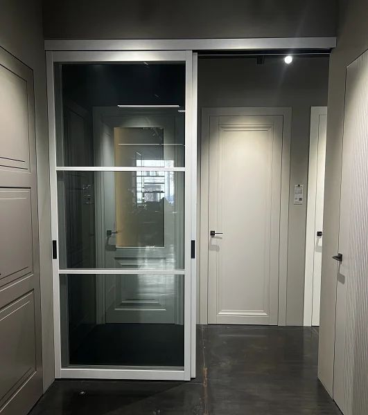 Раздвижная перегородка STRATUS-DOMINO, модель DM-03, безопасное прозрачное серое стекло, каркас полотна в белом цвете. Трек видимый.