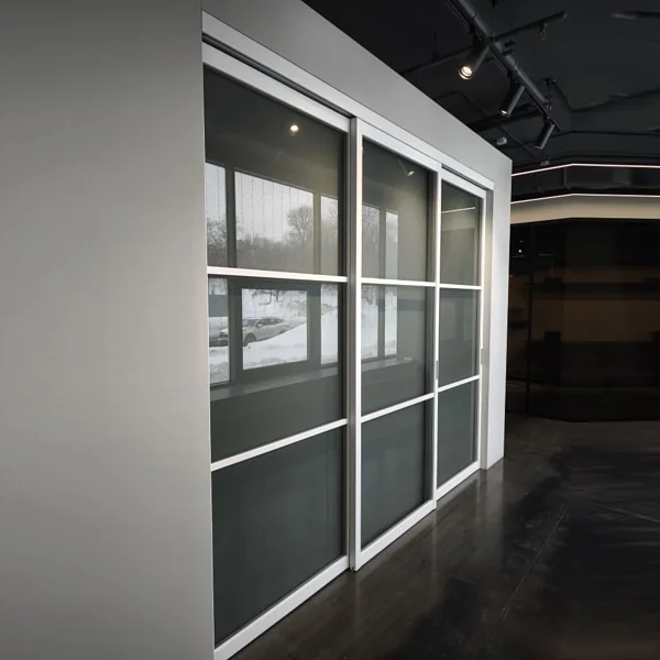 Раздвижная перегородка STRATUS-DOMINO, модель DM-03, безопасное прозрачное стекло, каркас полотна в белом цвете. Трек видимый.